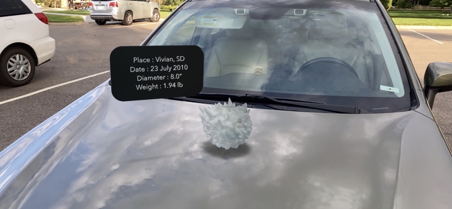 An AR model of a hailstone sitting on top of a car.