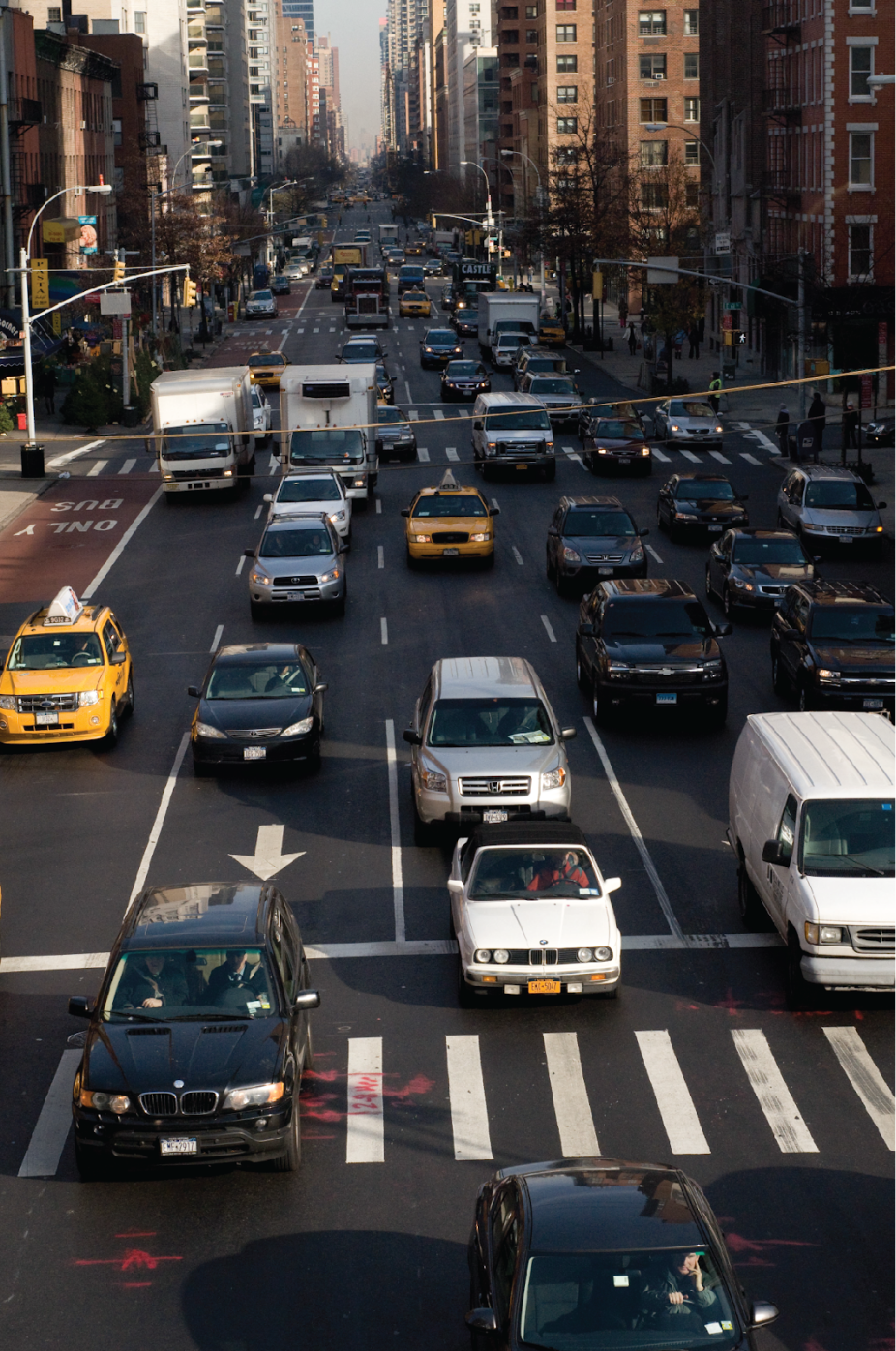 Cars drive along a busy city street