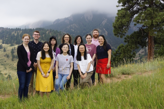 A group of postdocs pose in a mountainous landscape