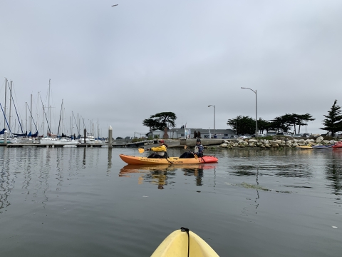 Two REU students paddle a kayak in the bay