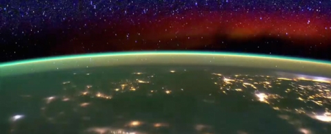 The layers of the ozone including a thin green line with city lights seen on Earth.