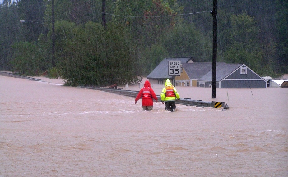 Workers walk through a flooded street in Powder Springs, GA.