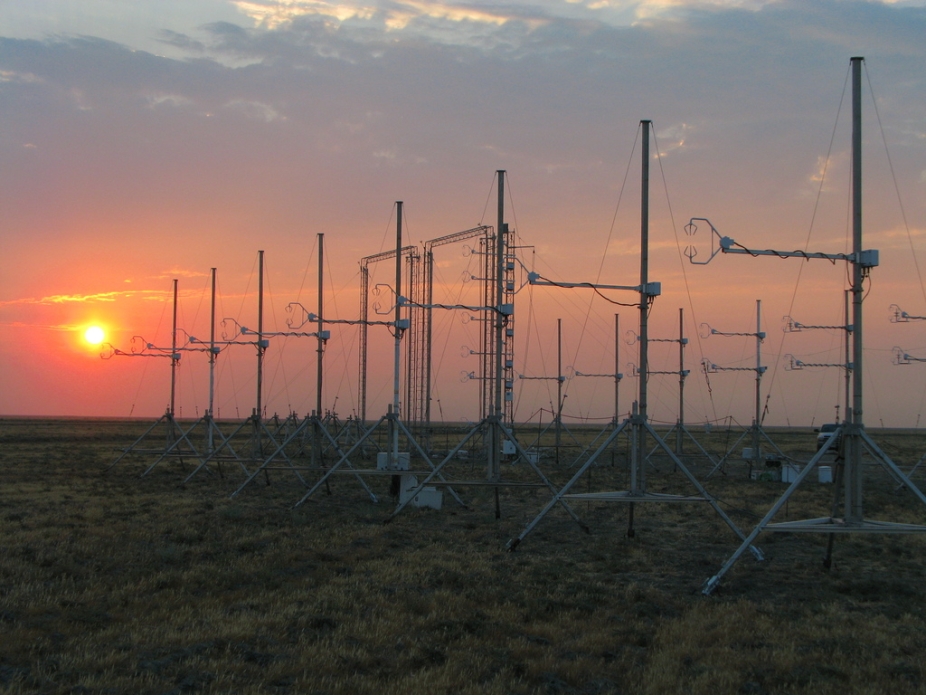 Weather instruments lined up in a field as the sun sets