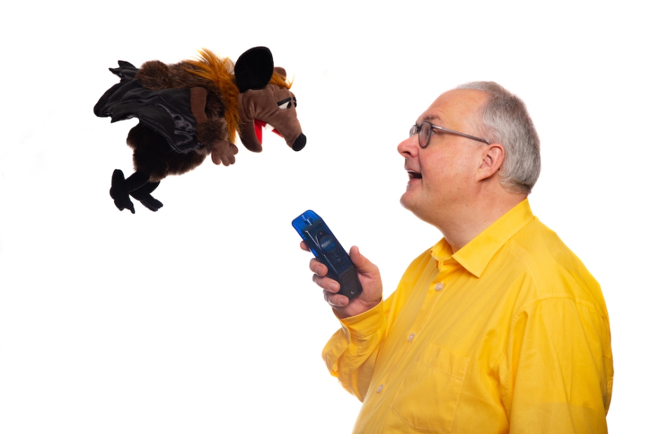 Scientist holding an ultrasound sensor with a flying (stuffed animal) bat. 