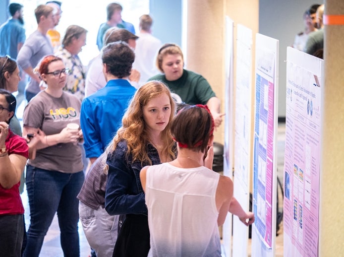 REU students presenting their research at a poster session