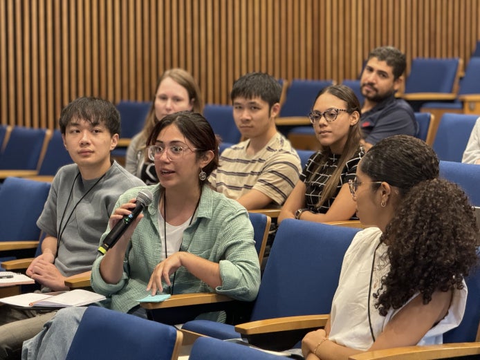 Graduate students in the NSF NCAR Mesa Lab auditorium hold a group discussion.