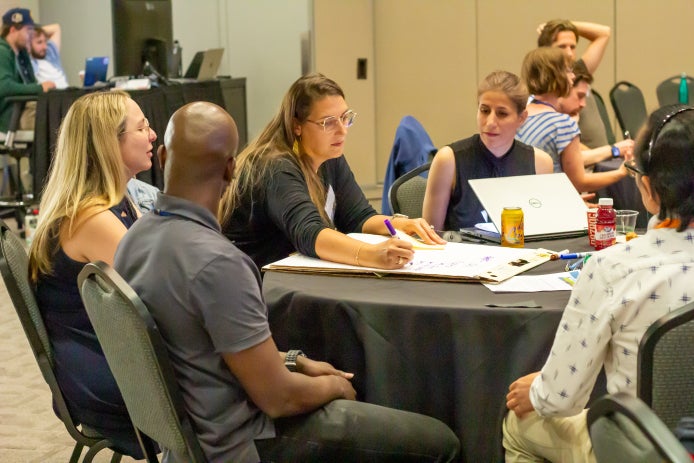 University faculty sit around a table and brainstorm ideas