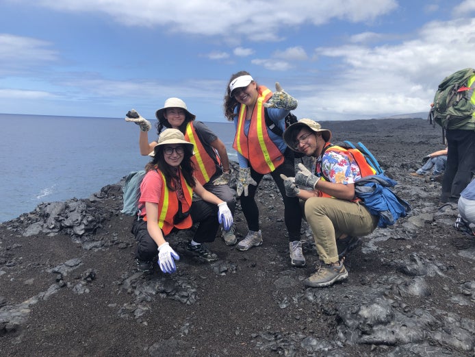 4 students on rocks participating in an REU