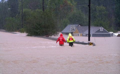 Workers walk through a flooded street in Powder Springs, GA. 