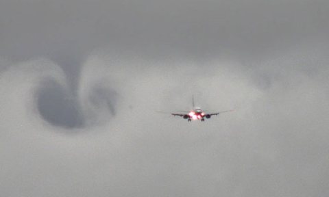 A plane coming in for a landing on a cloudy day