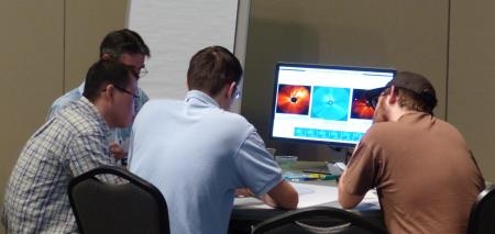 Students working together in front of a computer displaying solar images.