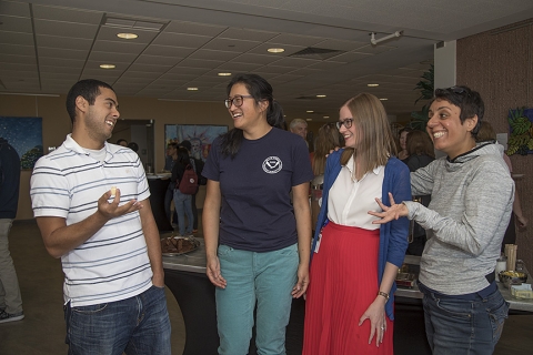 Four postdoctoral fellows greet each other