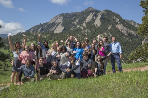 A group of students pose together in front of the Boulder Flatirons