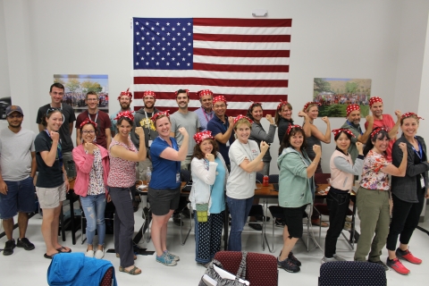 A group of scientists pose like Rosie the Riveter