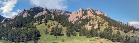 A scenic view of mountains with a green valley in the foreground